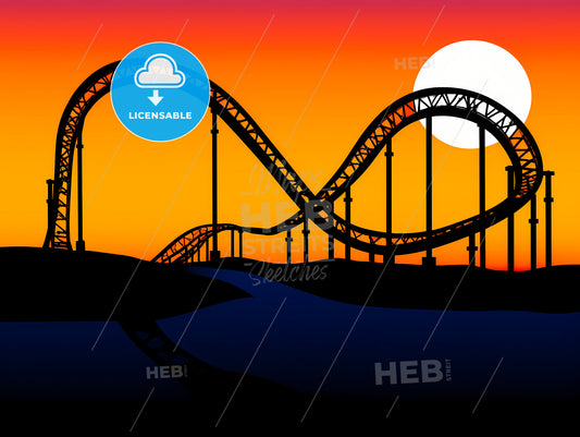 Roller coaster loop silhouetted at sunset